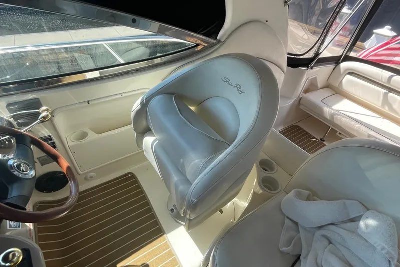 Irish Rover Yacht Photos Pics Interior of 2006 Sea Ray 360 Sundancer with helm, leather seating, and wooden accents.