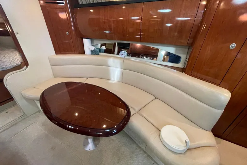Irish Rover Yacht Photos Pics Luxurious interior of 2006 Sea Ray 360 Sundancer with curved seating and polished wood table.