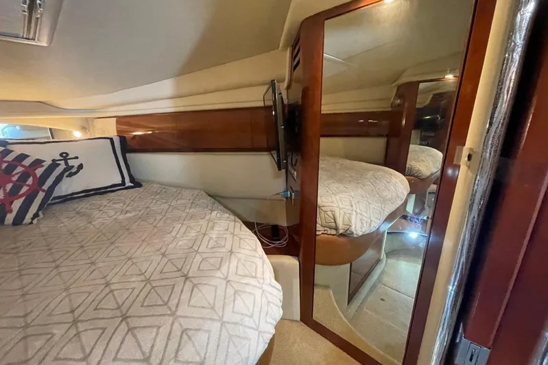Irish Rover Yacht Photos Pics 2006 Sea Ray 360 Sundancer cabin with bed, nautical pillow, and mirrored closet.