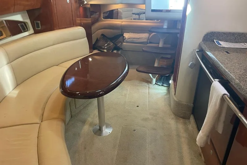 Irish Rover Yacht Photos Pics Interior of 2006 Sea Ray 360 Sundancer with beige seating and wooden table.