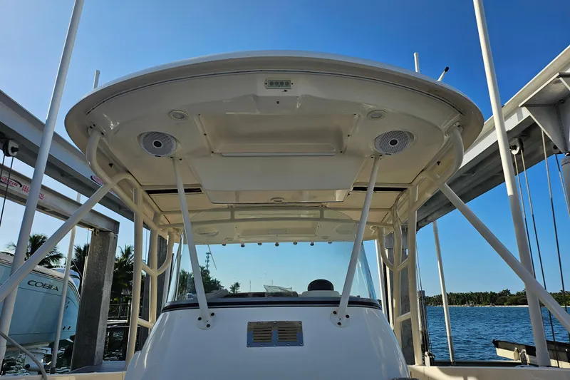  Yacht Photos Pics 2012 Pursuit C 310 Center Console boat with T-top, docked by the water.
