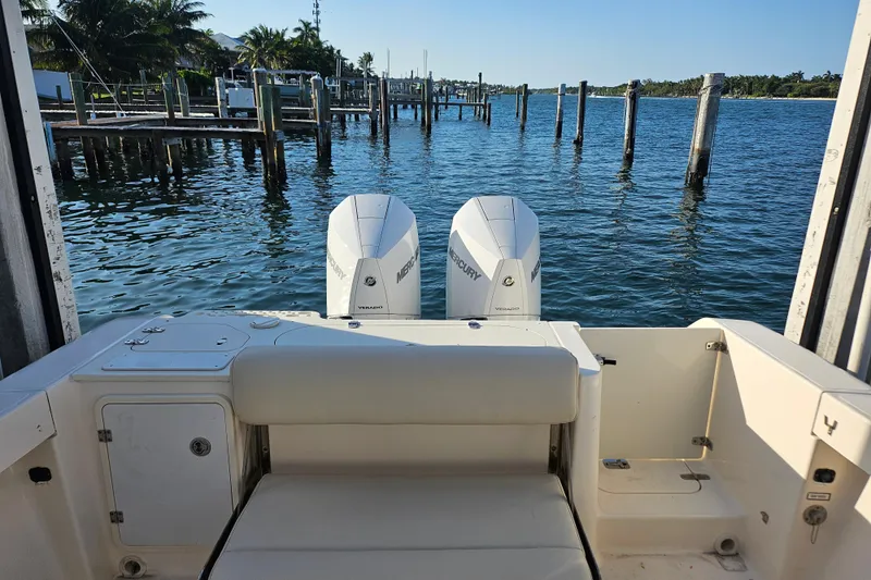 Yacht Photos Pics 2012 Pursuit C 310 Center Console boat with twin Mercury engines docked by the water.