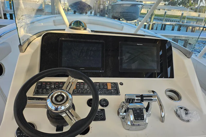  Yacht Photos Pics 2012 Pursuit C 310 Center Console boat dashboard with steering wheel and navigation screens.