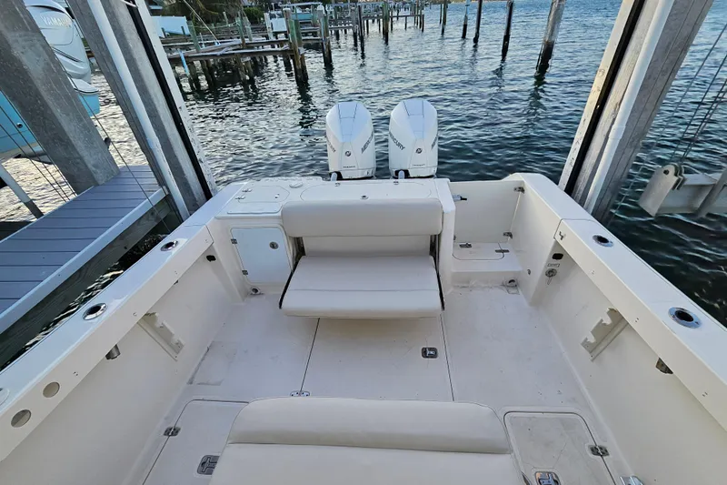  Yacht Photos Pics 2012 Pursuit C 310 Center Console boat with dual engines, docked by the water.
