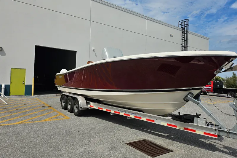  Yacht Photos Pics 2012 Pursuit C 310 Center Console boat on trailer outside warehouse.