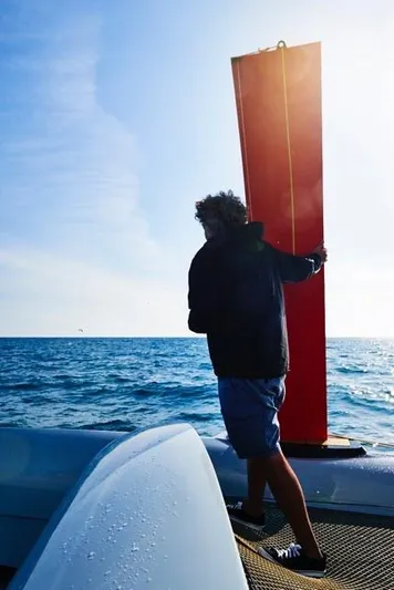  Yacht Photos Pics Person on Westerly GF 42 Custom boat holding a red sail, ocean background.