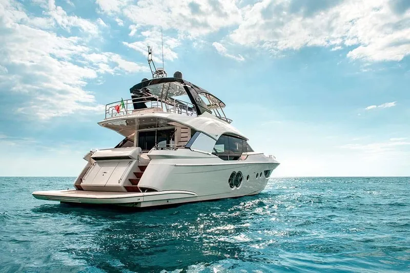 Illuzion Yacht Photos Pics Luxury Monte Carlo Yachts MCY 70, 2020 model, cruising on open sea under blue sky.