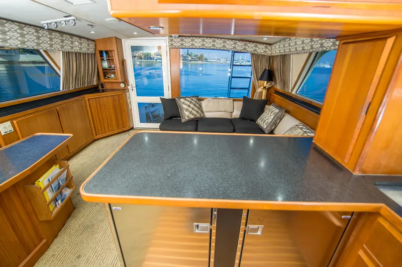 Aquila II Yacht Photos Pics Luxurious interior of 1990 Bertram 50 Convertible yacht with elegant wood finishes.