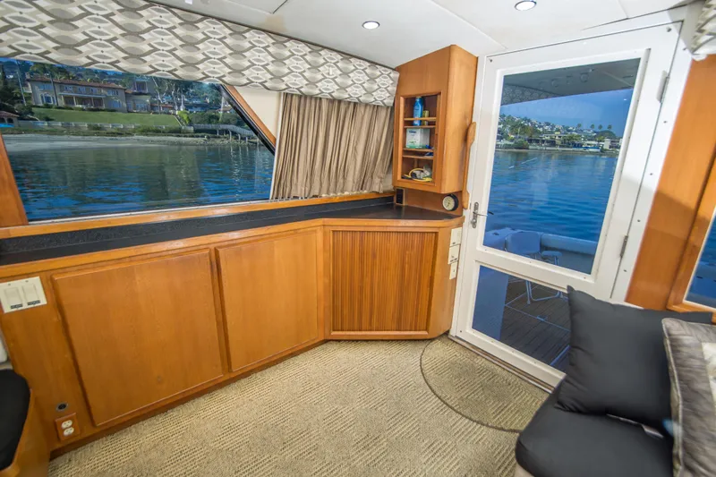 Aquila II Yacht Photos Pics Interior of 1990 Bertram 50 Convertible yacht with wood cabinetry and waterfront view.