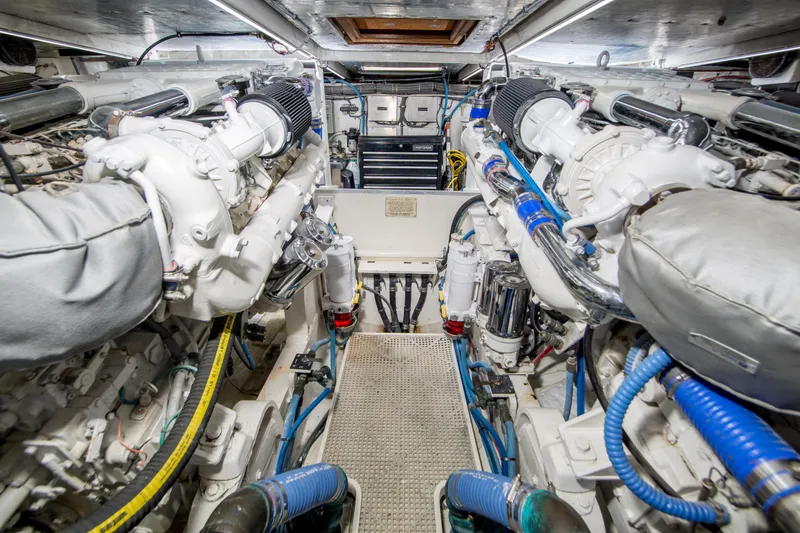 Aquila II Yacht Photos Pics Engine room of a 1990 Bertram 50 Convertible yacht, showcasing dual engines and mechanical components.