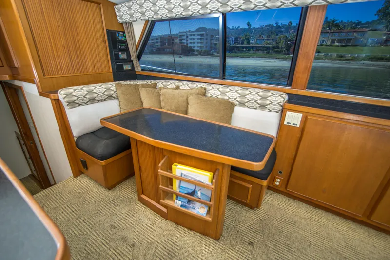 Aquila II Yacht Photos Pics Interior of 1990 Bertram 50 Convertible yacht with cozy seating and scenic window view.