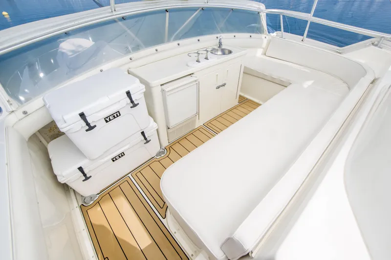 Aquila II Yacht Photos Pics Luxurious 1990 Bertram 50 Convertible yacht interior with seating, coolers, and sink.