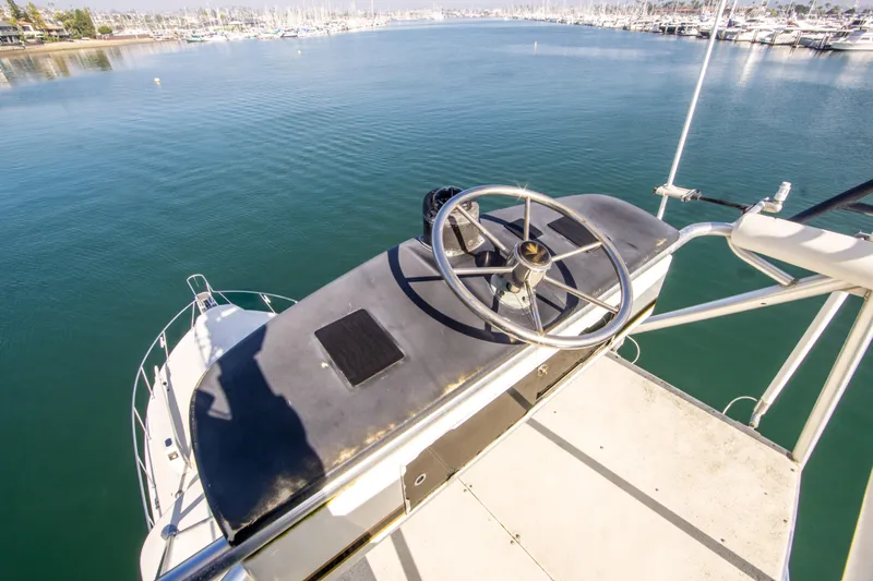 Aquila II Yacht Photos Pics Helm of 1990 Bertram 50 Convertible yacht overlooking marina waters.