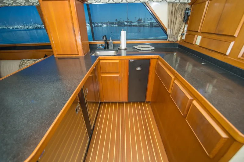 Aquila II Yacht Photos Pics Luxurious kitchen interior of 1990 Bertram 50 Convertible yacht with wood cabinetry and ocean view.