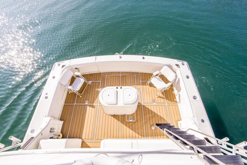 Aquila II Yacht Photos Pics Bertram 50 Convertible 1990 yacht deck with chairs, overlooking sparkling water.