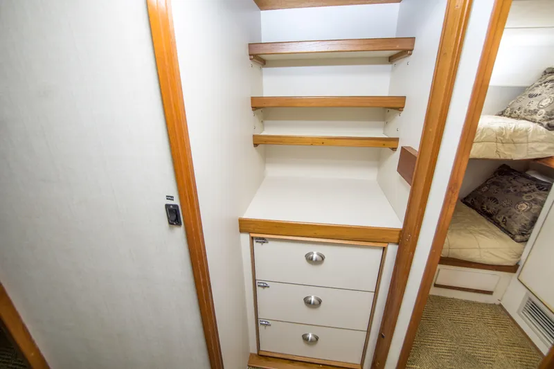 Aquila II Yacht Photos Pics Interior storage space with shelves and drawers on a 1990 Bertram 50 Convertible yacht.