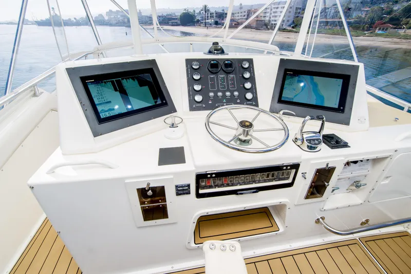 Aquila II Yacht Photos Pics 1990 Bertram 50 Convertible yacht helm with dual navigation screens and steering wheel.