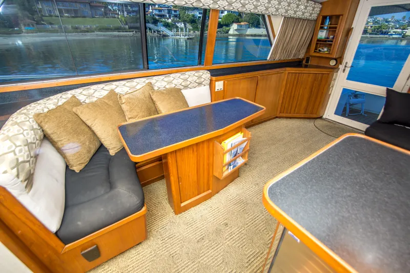Aquila II Yacht Photos Pics Interior of 1990 Bertram 50 Convertible yacht with cozy seating and waterfront view.