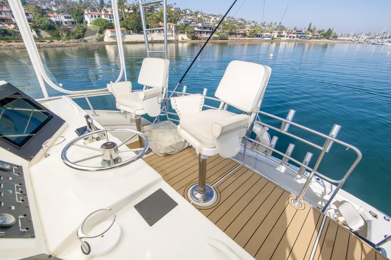 Aquila II Yacht Photos Pics Bertram 50 Convertible 1990 yacht helm with white seats and scenic harbor view.