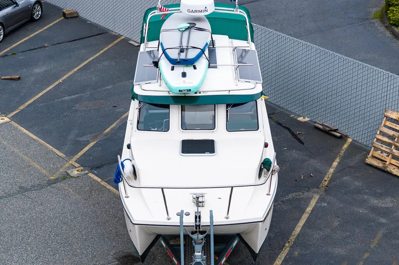 Pretty Penny Yacht Photos Pics 2006 C-Dory 25' Tomcat Catamaran with paddleboard on top, parked in a lot.