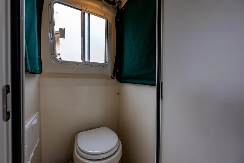 Pretty Penny Yacht Photos Pics 2006 C-Dory 25' Tomcat Catamaran bathroom with window and green curtain.