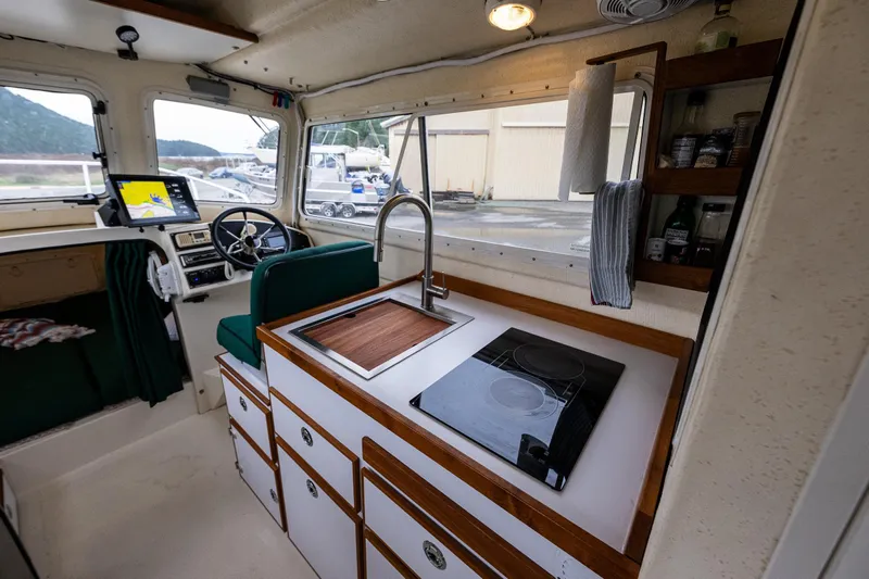 Pretty Penny Yacht Photos Pics Interior of a 2006 C-Dory 25' Tomcat Catamaran with kitchen and navigation area.