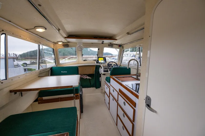 Pretty Penny Yacht Photos Pics Interior of 2006 C-Dory 25' Tomcat Catamaran with seating, table, and helm.