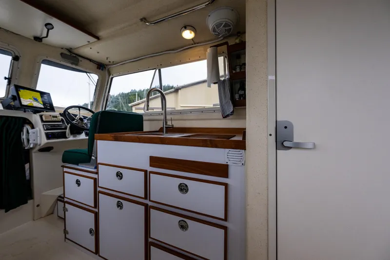 Pretty Penny Yacht Photos Pics Interior of 2006 C-Dory 25' Tomcat Catamaran with helm, sink, and storage cabinets.