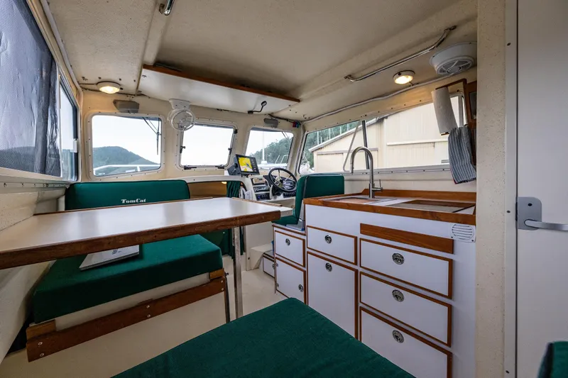 Pretty Penny Yacht Photos Pics Interior of 2006 C-Dory 25' Tomcat Catamaran with seating, table, and kitchenette.