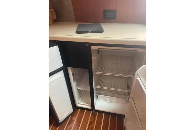 Son Days Yacht Photos Pics Open refrigerator in 2006 Tiara Yachts 3800 Open, featuring wooden flooring and countertop.