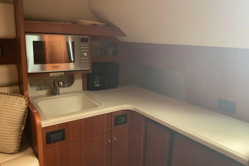 Son Days Yacht Photos Pics 2006 Tiara Yachts 3800 Open galley with microwave, sink, and wooden cabinetry.