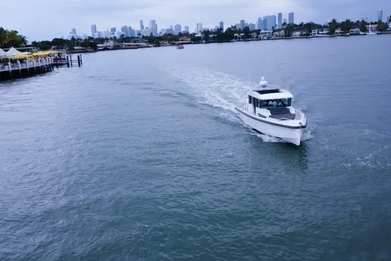 Wanderlust Yacht Photos Pics 2020 Axopar 37 XC Cross Cabin cruising near city skyline on calm waters.