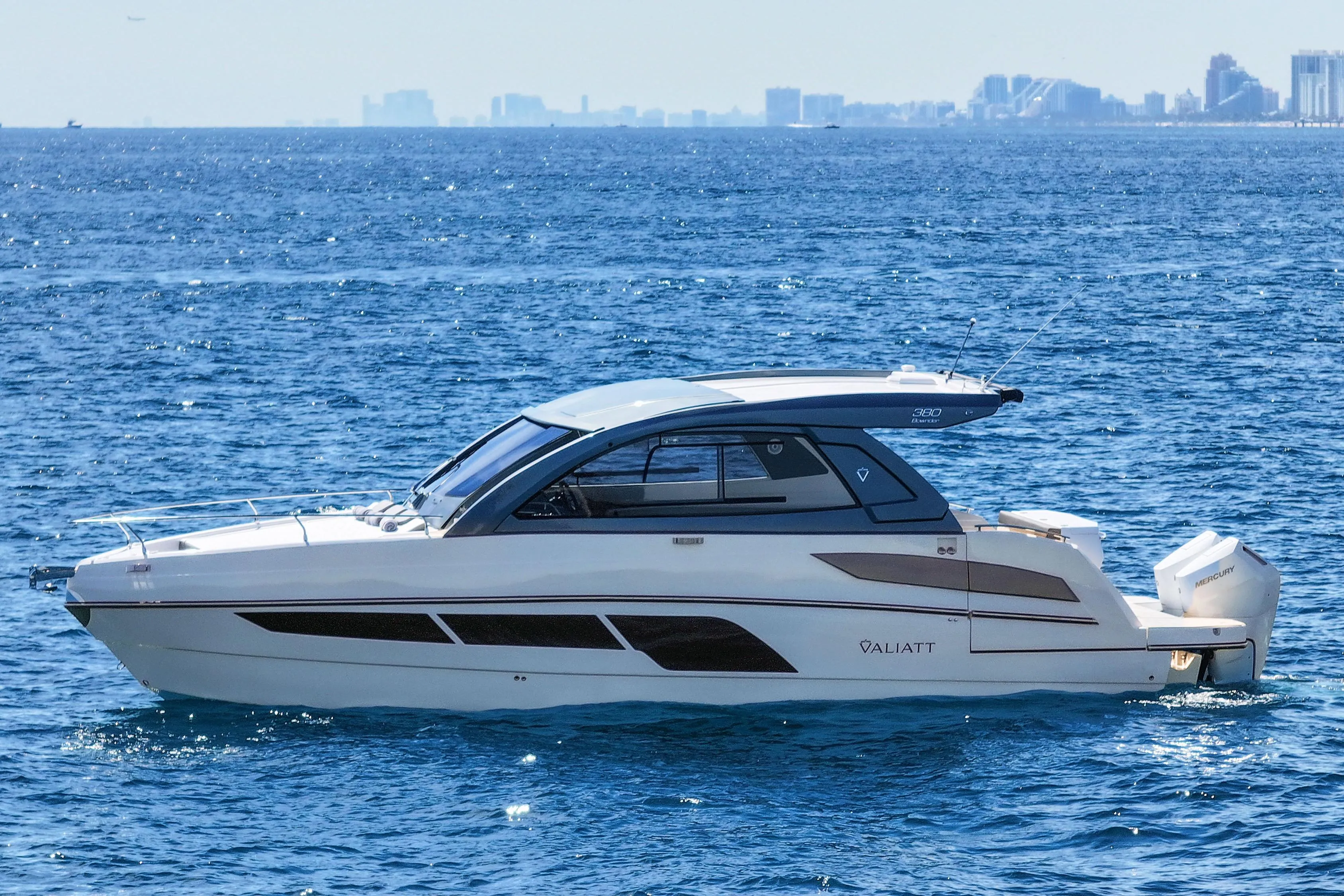 2025 VALIATT YACHTS 380 Bowrider cruising on open sea with city skyline in background.