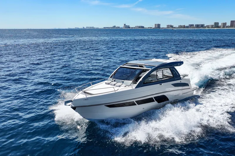  Yacht Photos Pics 2025 VALIATT YACHTS 380 Bowrider cruising on open ocean with city skyline backdrop.