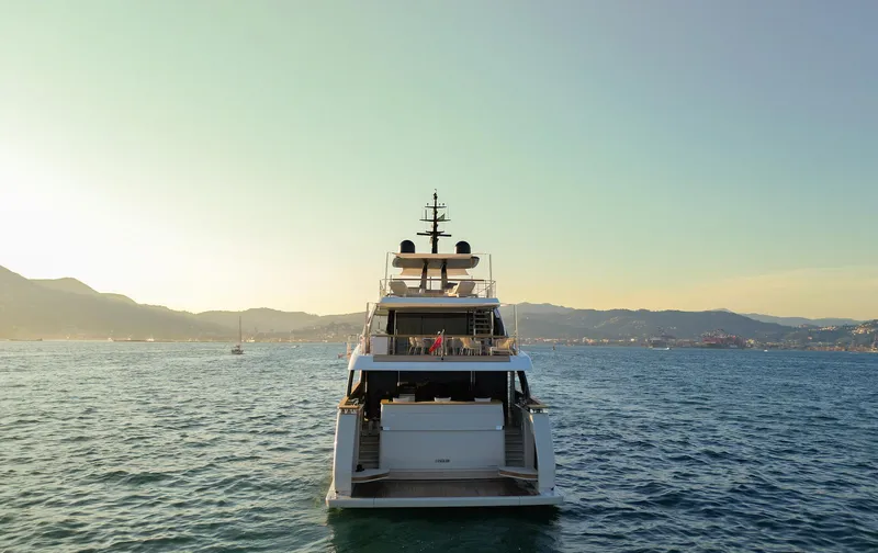  Yacht Photos Pics 2024 Sanlorenzo SD118 yacht on calm sea at sunset, mountains in background.