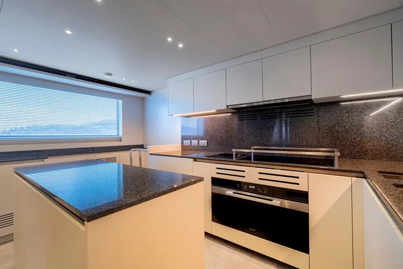 Yacht Photos Pics Modern kitchen interior on 2024 Sanlorenzo SD118 yacht, featuring sleek cabinetry and granite countertops.