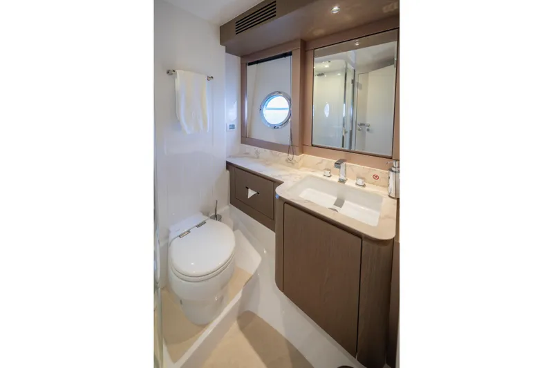 Seahawk Yacht Photos Pics Luxurious bathroom in 2025 Azimut Magellano 66 yacht with modern fixtures and porthole window.