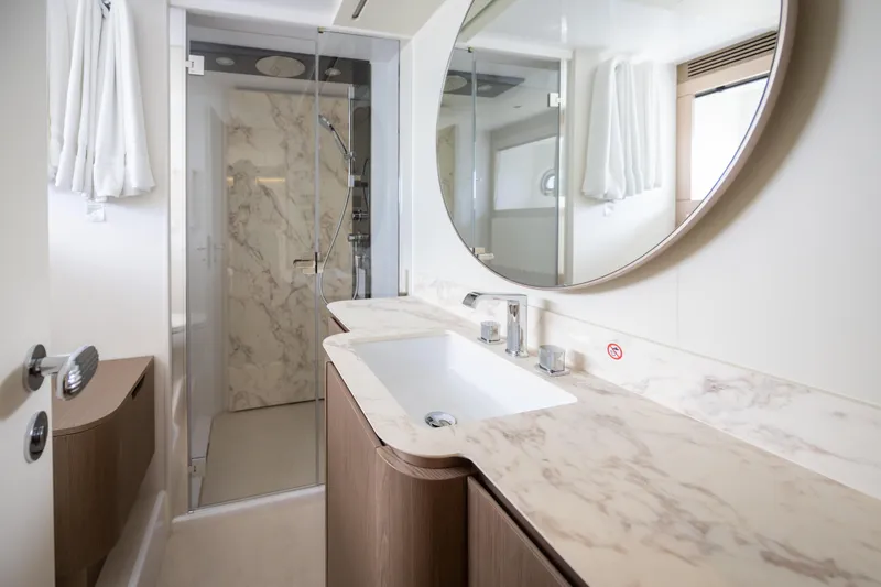Seahawk Yacht Photos Pics Luxurious bathroom in 2025 Azimut Magellano 66 yacht with marble accents and modern fixtures.