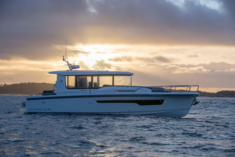  Yacht Photos Pics 2024 Nimbus C11 boat cruising at sunset on calm waters.
