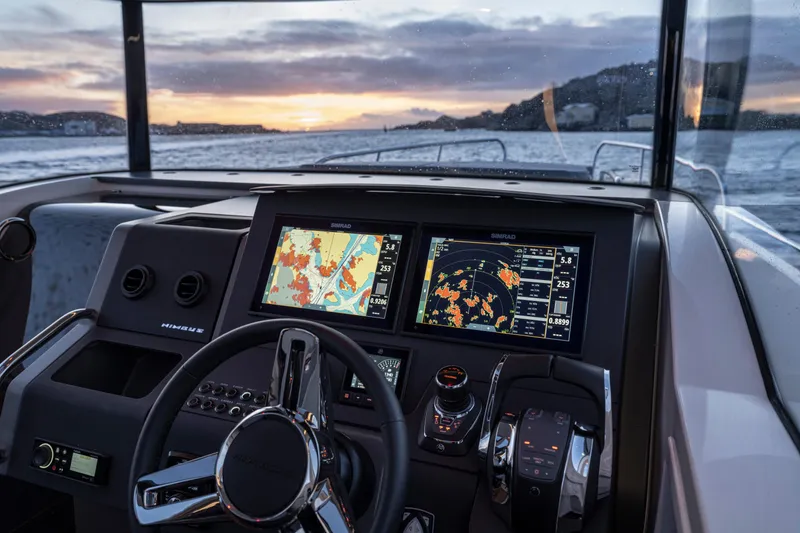  Yacht Photos Pics 2024 Nimbus C11 boat dashboard with navigation screens at sunset on the water.
