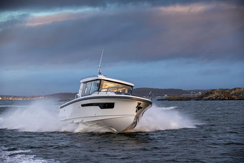 Yacht Photos Pics 2024 Nimbus C11 boat cruising on open water under a dramatic sky.
