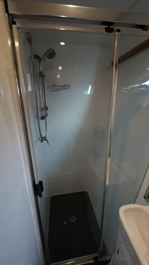 Sovereign Yacht Photos Pics Shower area in 2006 Lidgard Custom Catamaran with glass door and modern fixtures.