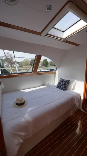 Sovereign Yacht Photos Pics Cozy bedroom in 2006 Lidgard Custom Catamaran with skylight and wooden flooring.