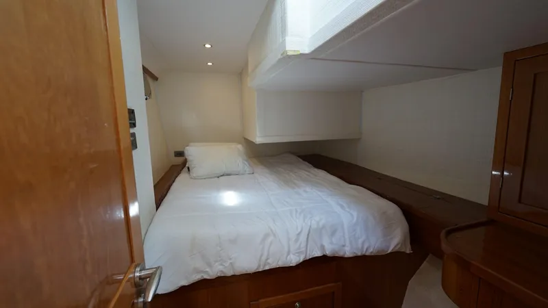 Sovereign Yacht Photos Pics Cozy bedroom in 2006 Lidgard Custom Catamaran with wooden furnishings and white bedding.