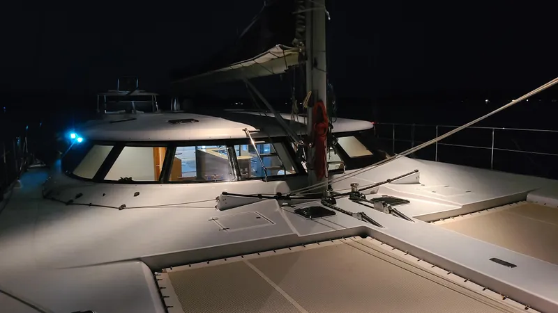 Sovereign Yacht Photos Pics 2006 Lidgard Custom Catamaran at night, featuring deck and cabin lighting.