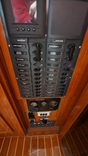 Sovereign Yacht Photos Pics Control panel on 2006 Lidgard Custom Catamaran, featuring switches and gauges on wooden paneling.