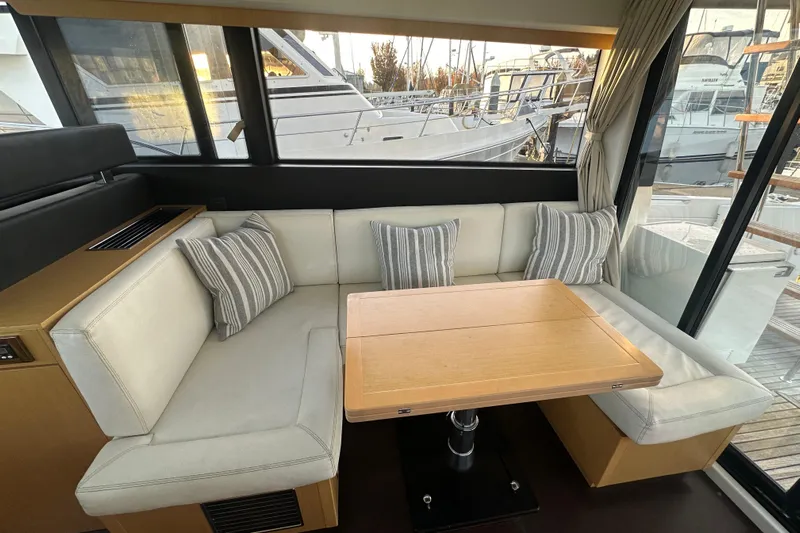 Couples Therapy Yacht Photos Pics Interior of 2014 Jeanneau Velasco 43 yacht with cozy seating and wooden table.