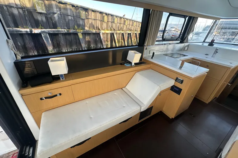 Couples Therapy Yacht Photos Pics Interior of 2014 Jeanneau Velasco 43 yacht with modern seating and kitchenette.