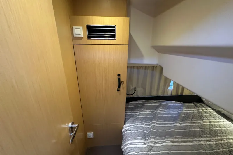 Couples Therapy Yacht Photos Pics Cozy cabin interior of 2014 Jeanneau Velasco 43 with bed and wooden cabinetry.