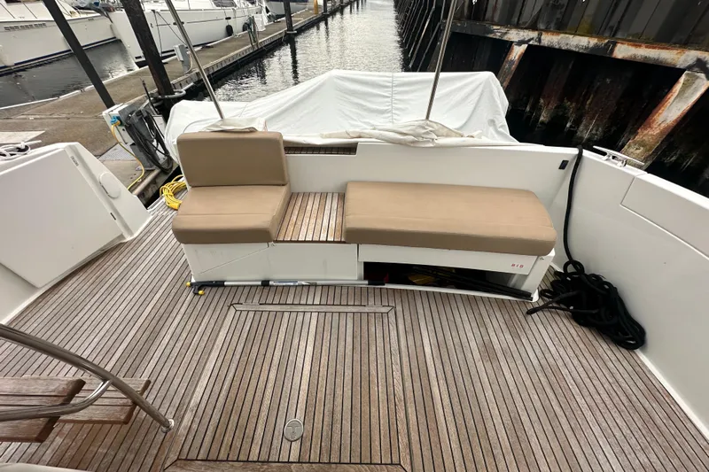 Couples Therapy Yacht Photos Pics 2014 Jeanneau Velasco 43 yacht deck with cushioned seating and wooden flooring.